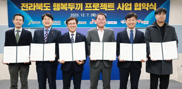 (왼쪽부터) 행복얼라이언스 사무국(행복나래㈜) 조민영 본부장, 전라북도 의회 강동화 의원, 자치분권포럼 이명연 이사장, 전라북도 김종훈 경제부지사, SK E&S ESG본부 류성선 본부장, 행복도시락 사회적협동조합 최준 사무국장이 협약식 체결 후 기념 촬영을 하고 있다. 사진 = 행복얼라이언스