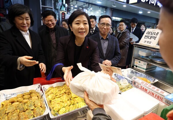 오영주 중소벤처기업부 장관이 지난 3일 서울 용산구 용문시장 상인회 사무실에서 열린 소상공인·전통시장 협·단체 현장간담회를 마친 뒤 전을 구입하고 있다. 사진 = 뉴시스