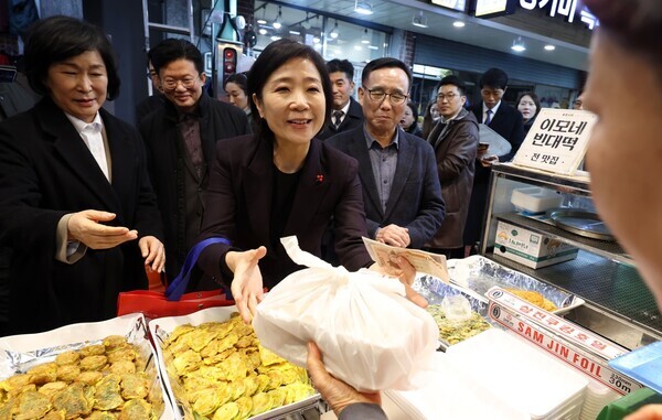 오영주 중소벤처기업부 장관이 지난 3일 서울 용산구 용문시장 상인회 사무실에서 열린 소상공인·전통시장 협·단체 현장간담회를 마친 뒤 전을 구입하고 있다. 사진 = 뉴시스